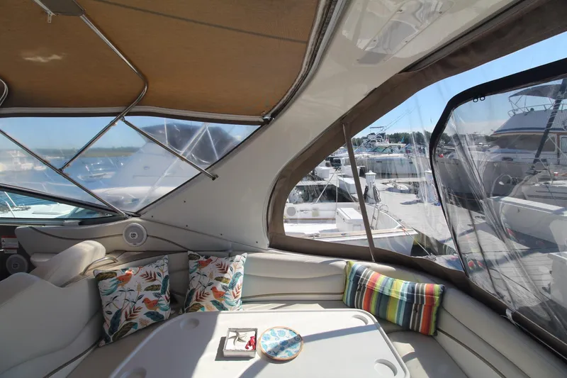 Slide: The Image of Interior view of 2004 Larson 370 Cabrio yacht with colorful cushions and marina backdrop. - 9