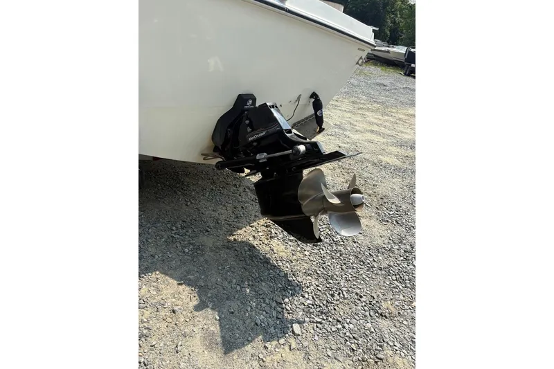 Slide: The Image of 1995 Baha Cruisers 240 Walkaround boat with MerCruiser outdrive on gravel surface. - 4