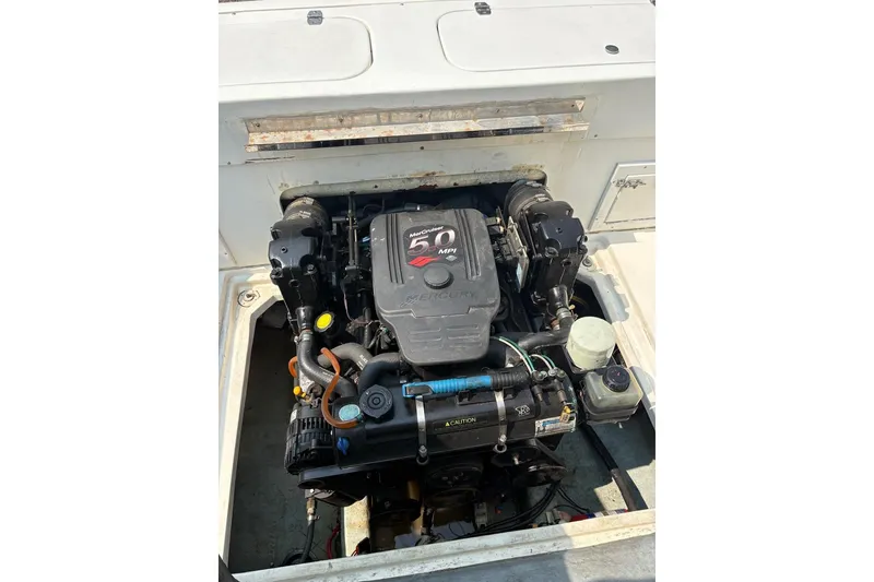 Slide: The Image of Engine compartment of a 1995 Baha Cruisers 240 Walkaround boat, featuring a MerCruiser 5.0 MPI engine. - 5