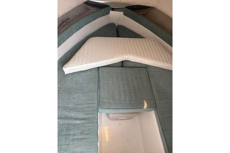 Slide: The Image of 1995 Baha Cruisers 240 Walkaround cabin interior with cushioned seating and storage. - 6