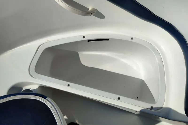 Slide: The Image of Storage compartment in a 2003 Sea-Doo Utopia 185 boat, featuring white and blue interior. - 15