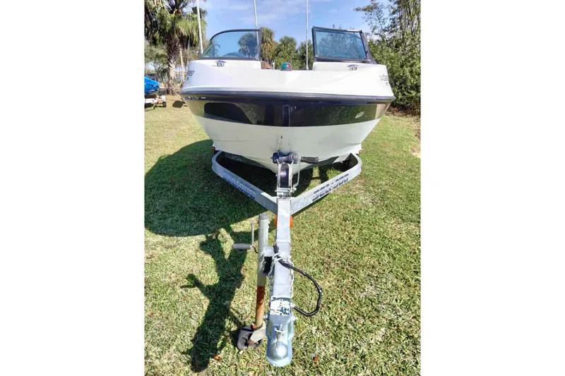 Slide: The Image of 2003 Sea-Doo Utopia 185 boat on trailer, parked on grass. - 2