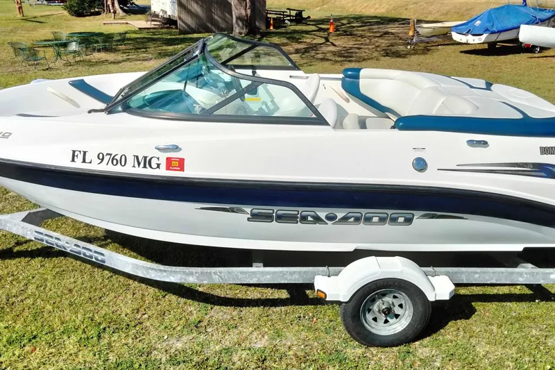 Slide: The Image of 2003 Sea-Doo Utopia 185 boat on trailer, parked on grass, side view. - 4