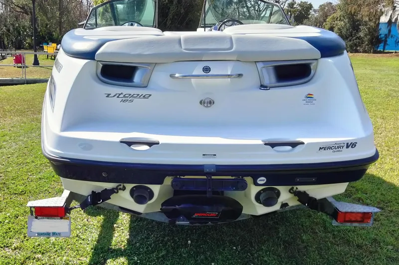 Slide: The Image of 2003 Sea-Doo Utopia 185 boat rear view, featuring Mercury V6 engine, on grass. - 7