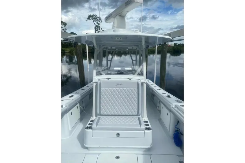 Slide: The Image of 2022 Yellowfin 32 boat interior with seating, docked on a calm waterway. - 5