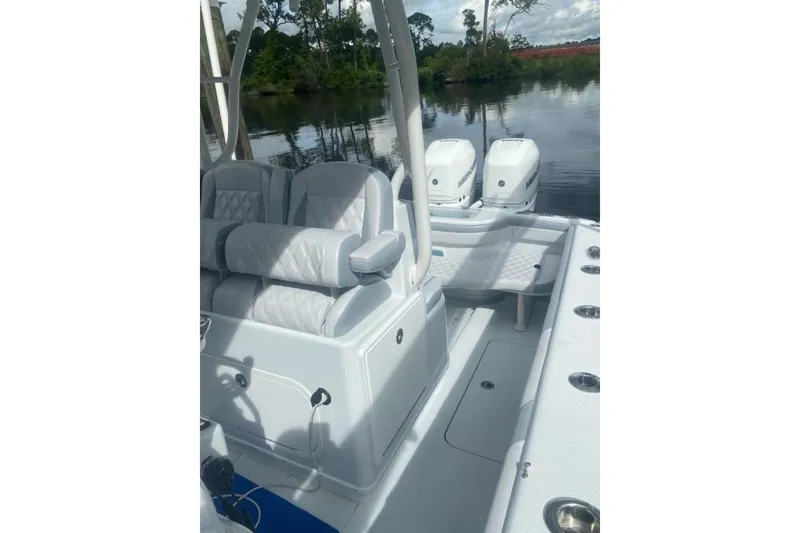 Slide: The Image of 2022 Yellowfin 32 boat interior with seating and dual engines on a calm water backdrop. - 7