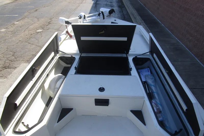 Slide: The Image of 2025 Ranger RB210 boat interior with open storage compartments on a sunny day. - 11