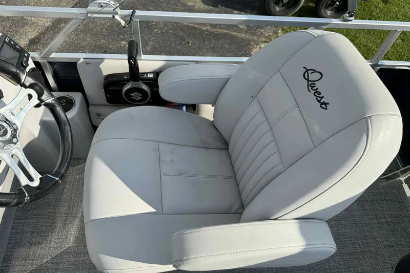 Slide: The Image of Captain's chair in 2019 Qwest 816 Luxury Series boat, featuring sleek design and steering wheel. - 12