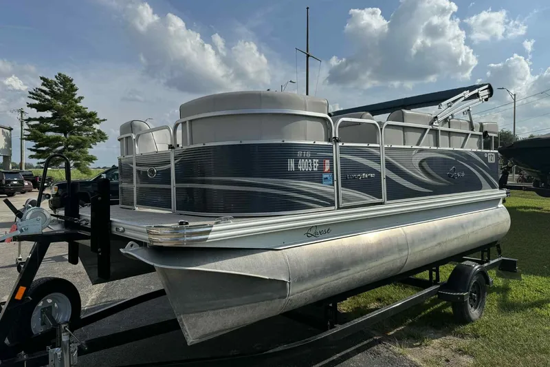 Slide: The Image of 2019 Qwest 816 Luxury Series pontoon boat on trailer, parked outdoors. - 2