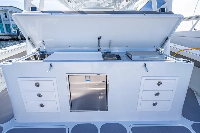 Slide: The Image of 2024 Yellowfin 54 Offshore boat kitchen with sink, grill, and storage drawers. - 35