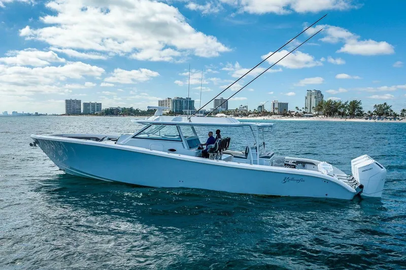 Slide: The Image of 2024 Yellowfin 54 Offshore boat cruising near city skyline on a sunny day. - 5