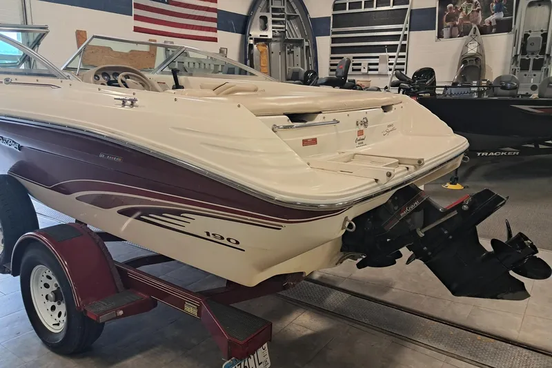 Slide: The Image of 1996 Sea Ray 190 Bow Rider boat on trailer in showroom, American flag in background. - 3