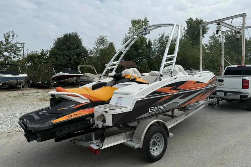 Slide: The Image of 2024 Galar Boats Typhoon with Seadoo GTI SE 155 on trailer, parked outdoors. - 6