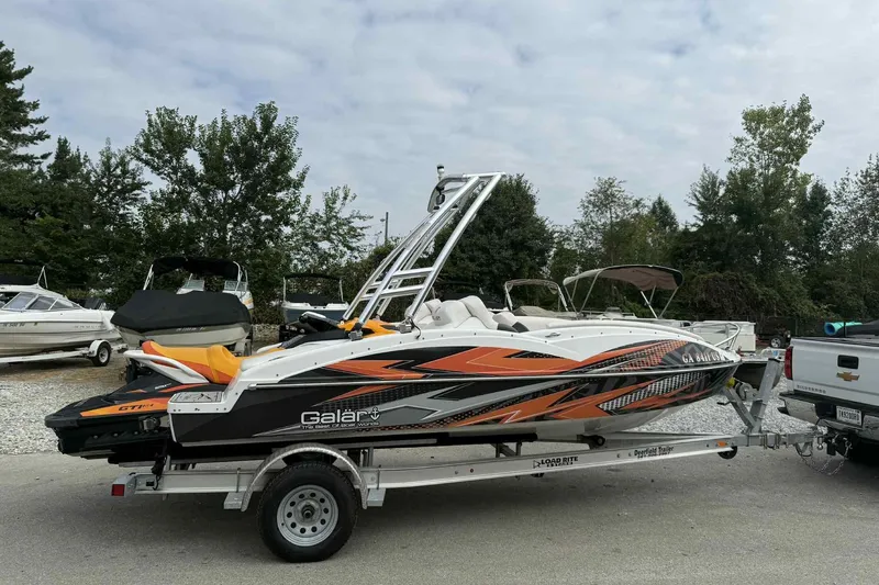 Slide: The Image of 2024 Galar Boats Typhoon with Seadoo GTI SE 155 on trailer, parked outdoors. - 7