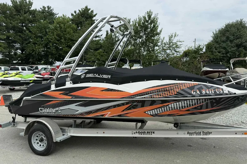 Slide: The Image of 2024 Galar Boats Typhoon with Seadoo GTI SE 155 on trailer, vibrant design. - 8