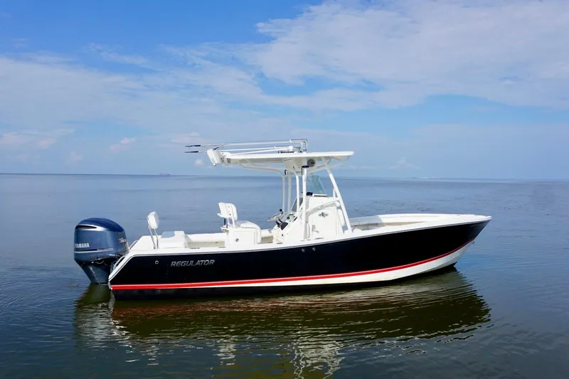 The Image of 2009 Regulator 24 FS boat on calm water under a clear blue sky. - 1