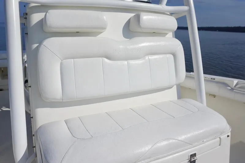 Slide: The Image of 2009 Regulator 24 FS boat seat with white cushioned upholstery on a calm water backdrop. - 11
