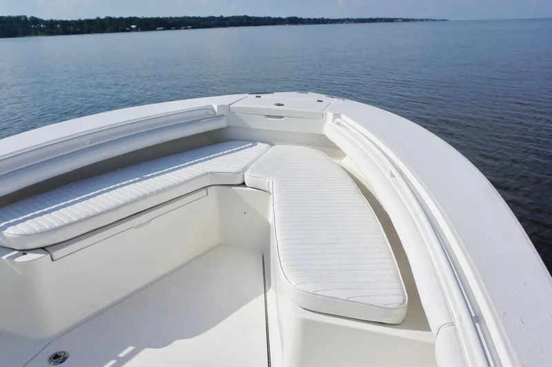 Slide: The Image of 2009 Regulator 24 FS boat with white cushioned seating on calm water. - 8