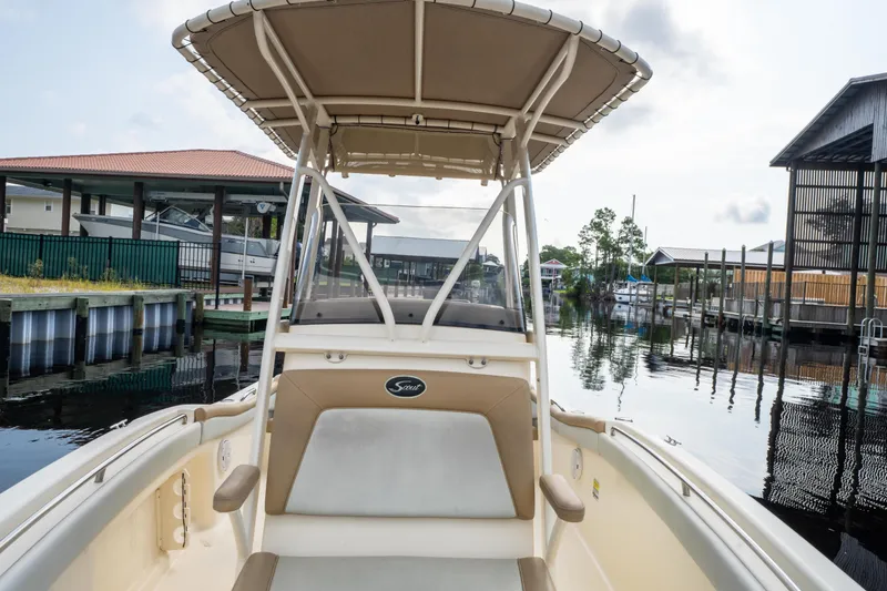 Slide: The Image of 2015 Scout 210 XSF boat docked in a serene marina setting. - 12