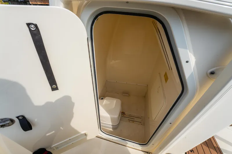 Slide: The Image of 2015 Scout 210 XSF boat interior with compact marine toilet. - 13