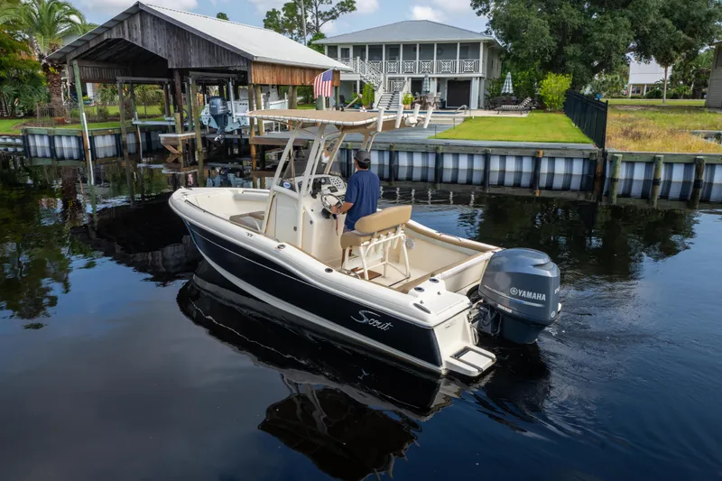 Slide: The Image of 2015 Scout 210 XSF boat with Yamaha engine on calm water near dock. - 2