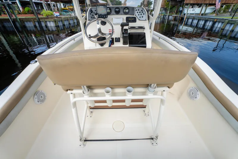 Slide: The Image of 2015 Scout 210 XSF boat interior with steering console and seating, dockside view. - 21