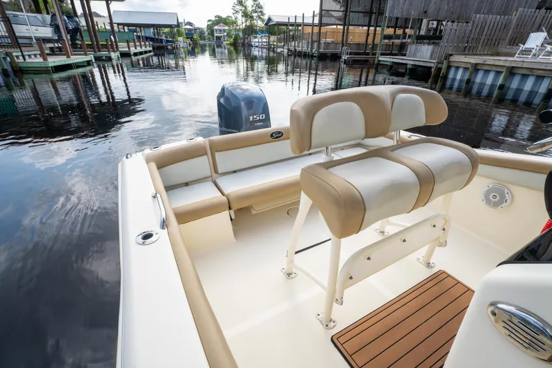 Slide: The Image of 2015 Scout 210 XSF boat interior with seating and outboard motor on a calm waterway. - 23