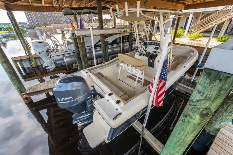 Slide: The Image of 2015 Scout 210 XSF boat docked with Yamaha outboard motor and American flag. - 26