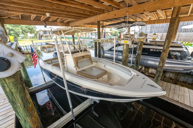 Slide: The Image of 2015 Scout 210 XSF boat docked under wooden shelter. - 27