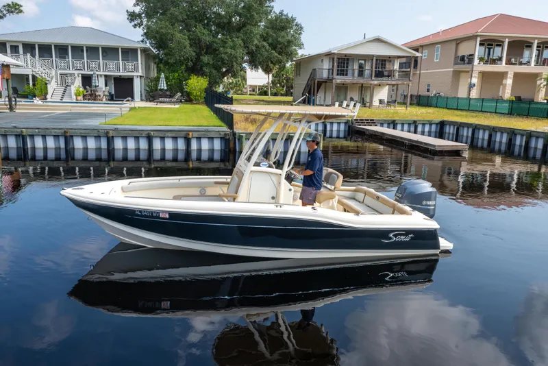 Slide: The Image of 2015 Scout 210 XSF boat on calm water near waterfront homes. - 3