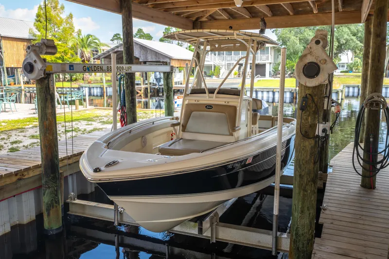 Slide: The Image of 2015 Scout 210 XSF boat on lift in marina, under covered dock. - 7