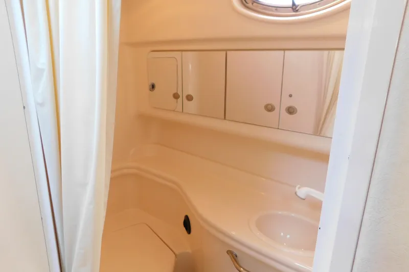 Slide: The Image of Bathroom interior of 2005 Sea Ray 320 Sundancer yacht, featuring sink and storage cabinets. - 104