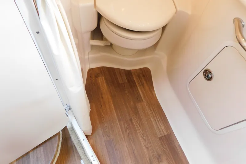 Slide: The Image of Bathroom interior of 2005 Sea Ray 320 Sundancer with wood flooring and compact toilet. - 106