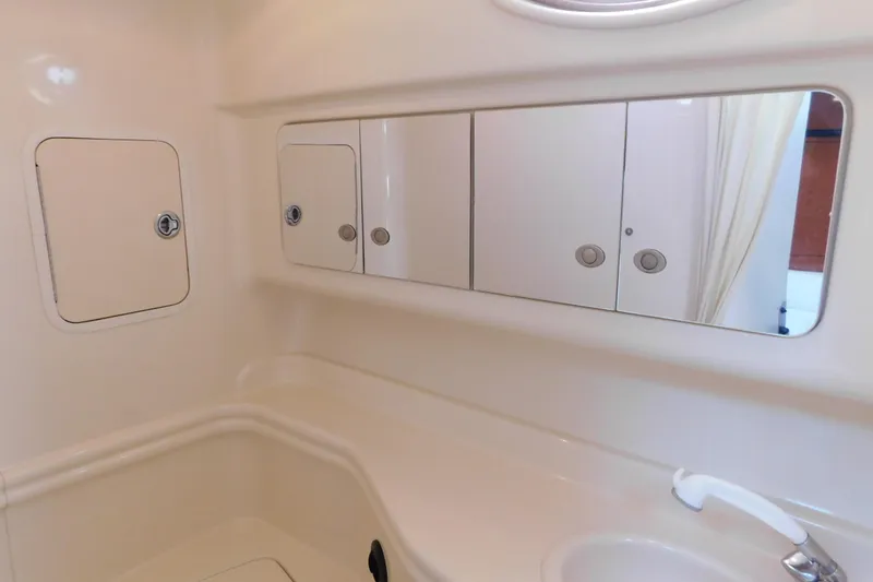 Slide: The Image of Interior of 2005 Sea Ray 320 Sundancer bathroom with mirror and storage cabinets. - 112