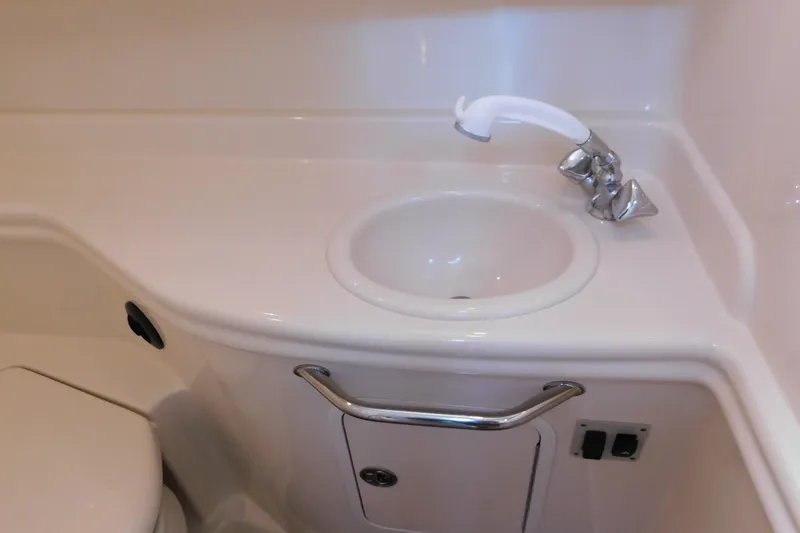 Slide: The Image of 2005 Sea Ray 320 Sundancer bathroom sink with faucet and storage cabinet. - 113