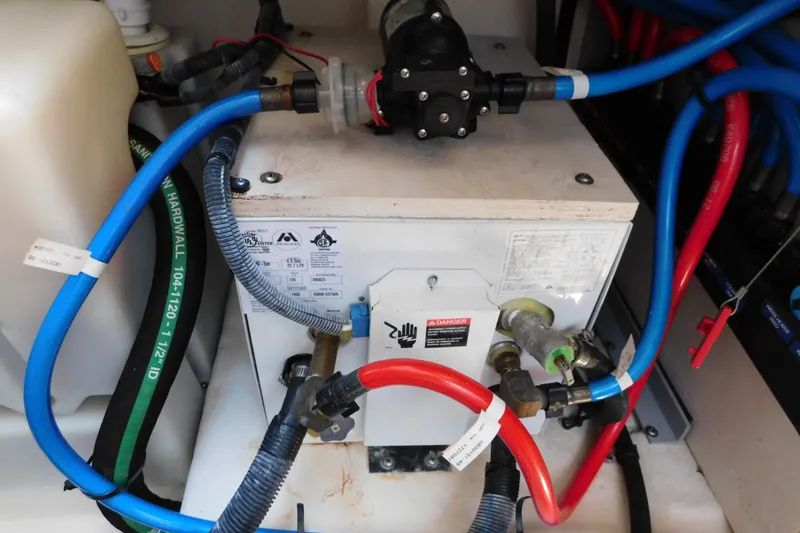 Slide: The Image of Engine compartment of a 2005 Sea Ray 320 Sundancer with visible hoses and components. - 121