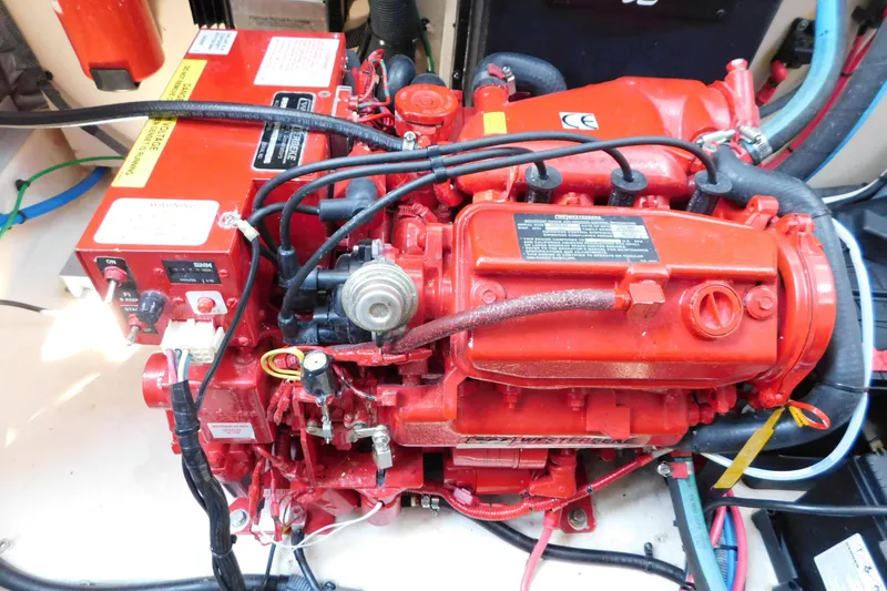 Slide: The Image of Engine compartment of a 2005 Sea Ray 320 Sundancer, featuring a red marine engine. - 122