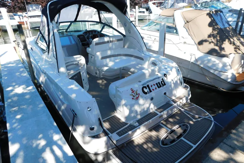 Slide: The Image of 2005 Sea Ray 320 Sundancer docked, featuring spacious seating and sleek design. - 13