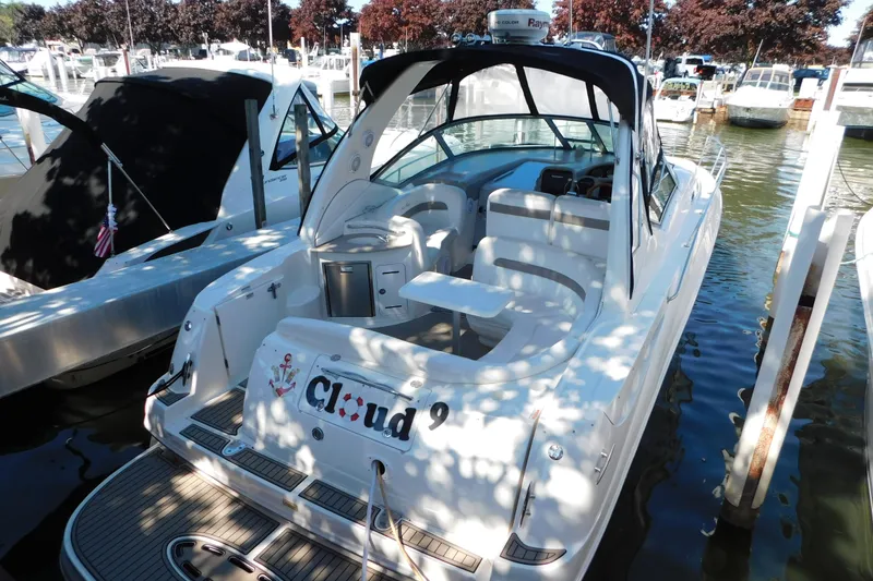 Slide: The Image of 2005 Sea Ray 320 Sundancer docked at marina, featuring spacious seating and sleek design. - 14