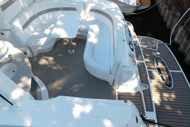 Slide: The Image of 2005 Sea Ray 320 Sundancer boat interior with seating and table, docked in sunlight. - 16