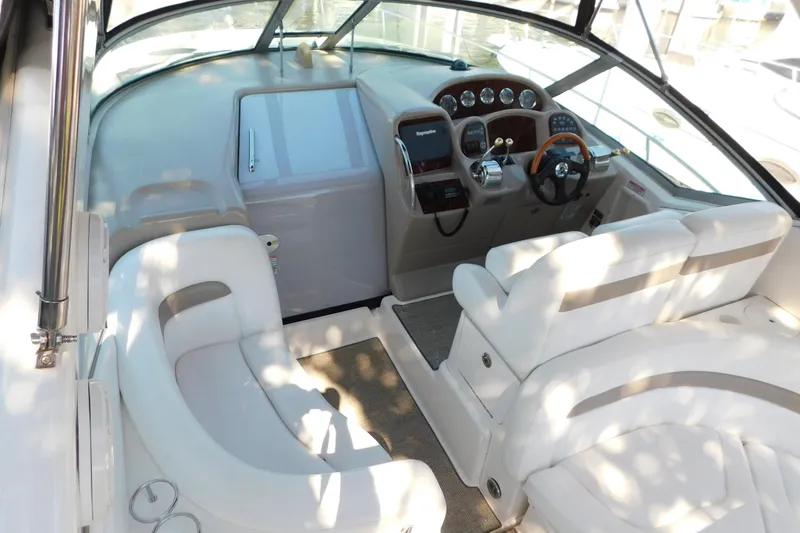 Slide: The Image of 2005 Sea Ray 320 Sundancer boat interior with helm, seating, and dashboard controls. - 17