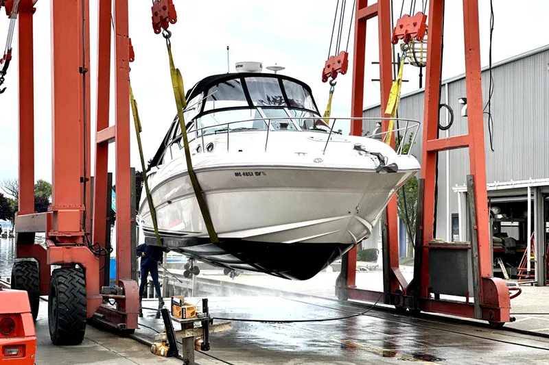 Slide: The Image of 2005 Sea Ray 320 Sundancer yacht being lifted for maintenance at a marina. - 2