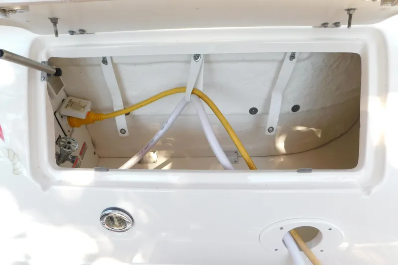 Slide: The Image of Open storage compartment on 2005 Sea Ray 320 Sundancer boat with cables and fittings. - 21