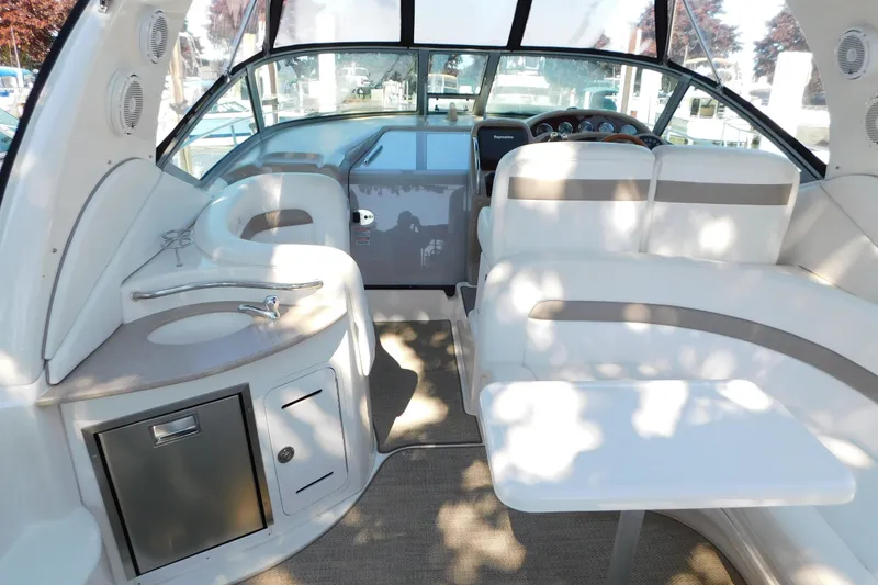 Slide: The Image of 2005 Sea Ray 320 Sundancer interior with white seating, sink, and helm. - 24