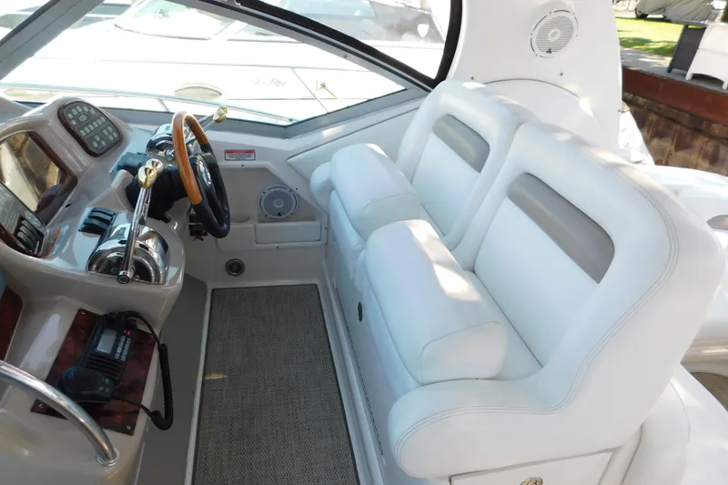 Slide: The Image of 2005 Sea Ray 320 Sundancer helm with white seating and control panel. - 29