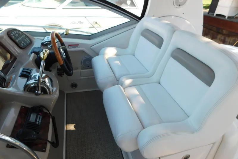 Slide: The Image of 2005 Sea Ray 320 Sundancer cockpit with white seating and control panel. - 30