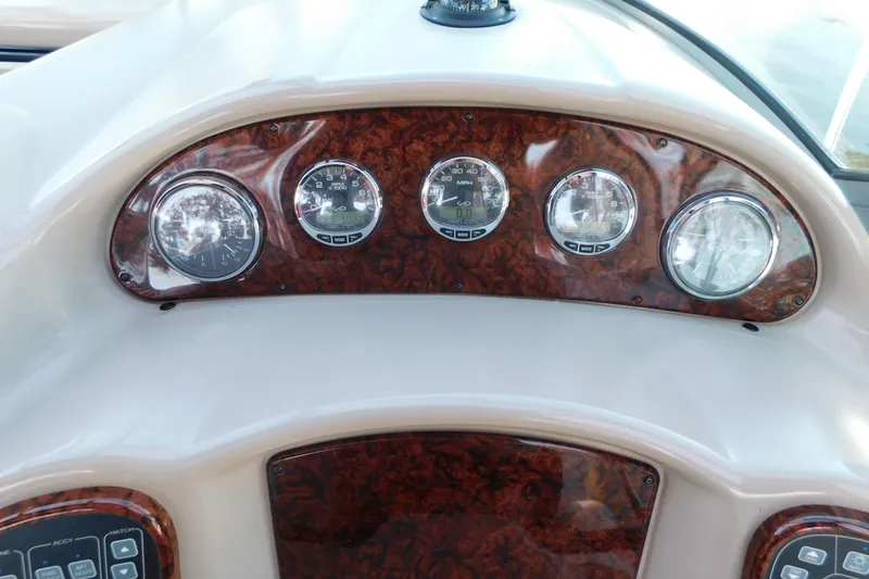 Slide: The Image of Dashboard of a 2005 Sea Ray 320 Sundancer boat with wood paneling and gauges. - 36