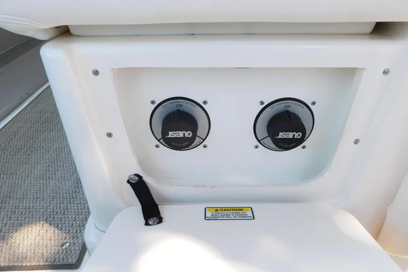 Slide: The Image of 2005 Sea Ray 320 Sundancer boat controls with caution label and carpeted flooring. - 47