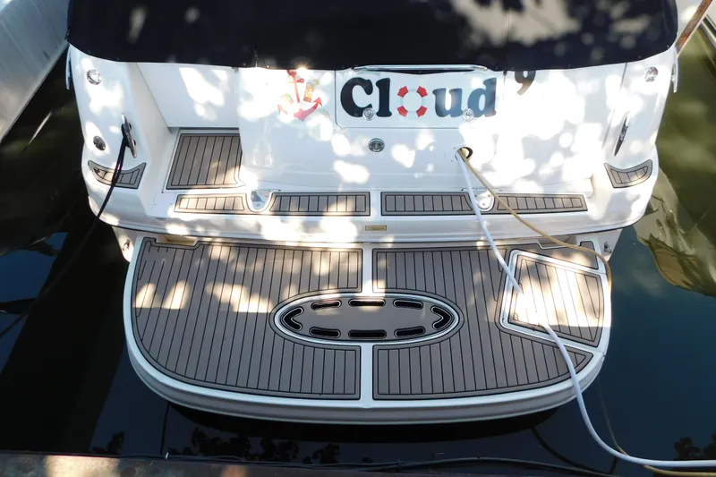 Slide: The Image of 2005 Sea Ray 320 Sundancer boat with custom deck, docked and partially shaded. - 5