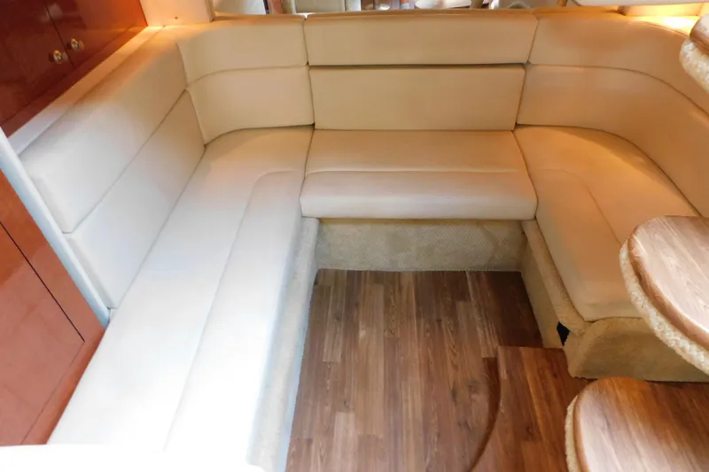 Slide: The Image of Luxurious interior seating of 2005 Sea Ray 320 Sundancer with beige upholstery and wooden flooring. - 53